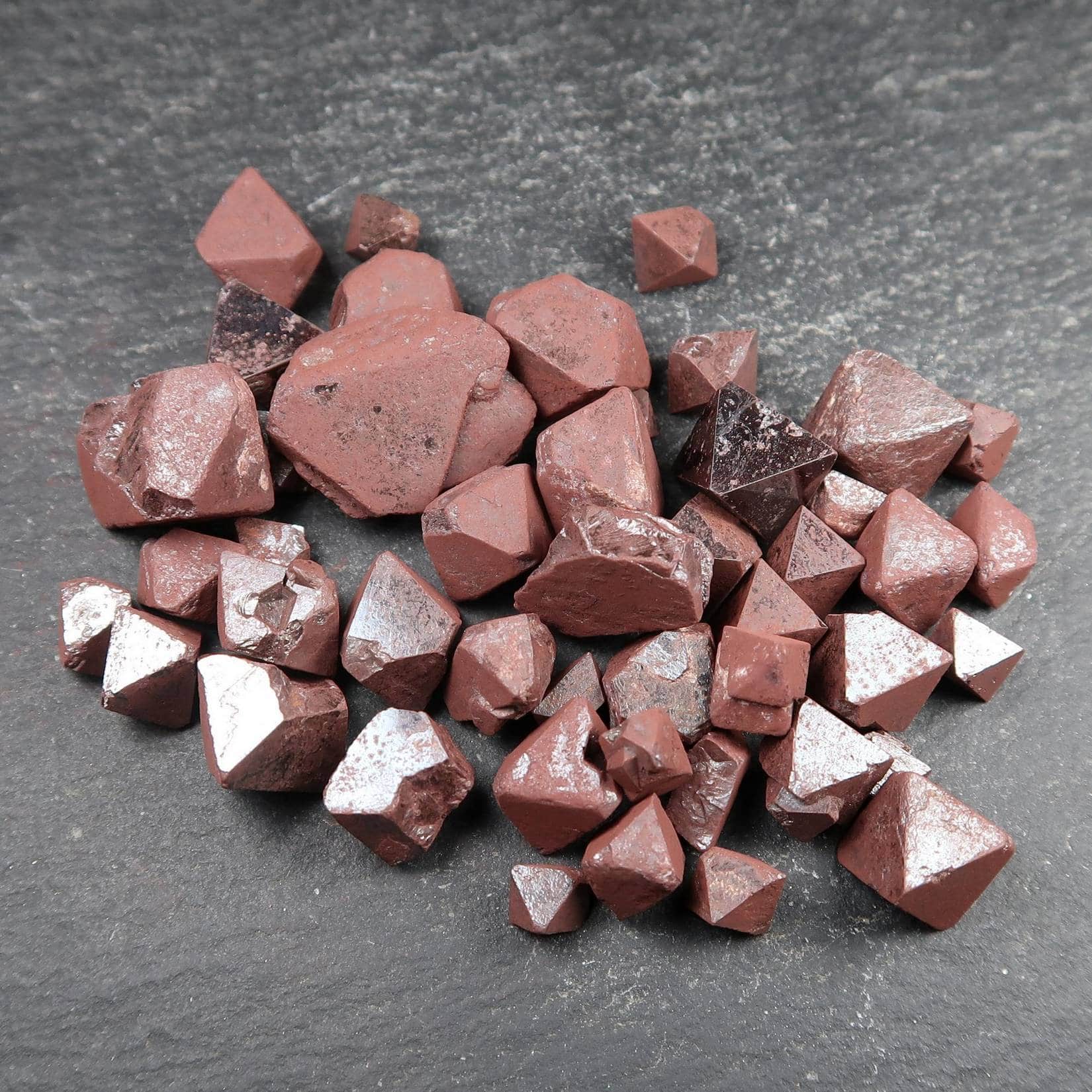 A mixture of red coated octahedral Magnetite crystals.